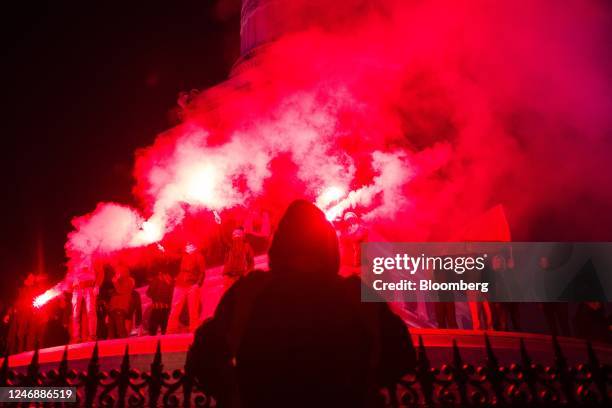 Demonstrators let off flares at the end a protest march at Place de Bastille during a national strike against government plans to revamp the pension...