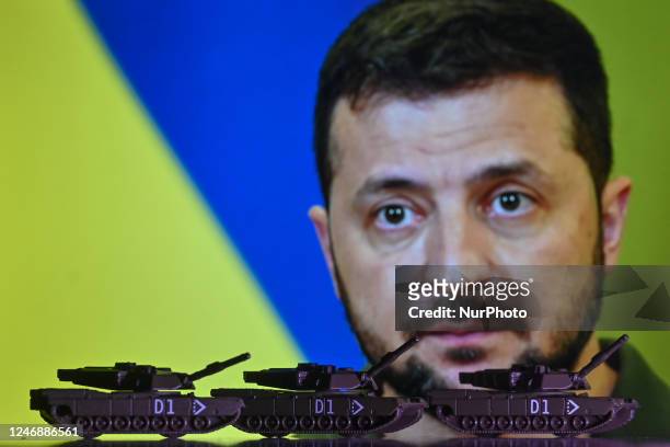 Illustration of a mini replica of Leopard tanks, seen in front of a photo of Volodymyr Zelenskiy, President of Ukraine, displayed on a computer...
