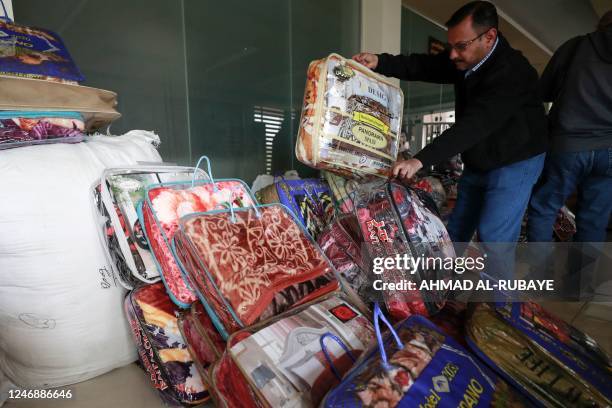 An Iraqi man arranges donation of blankets at the Turkmen Brotherhood Club headquarters in the capital Baghdad on February 8 to be sent to Turkey and...