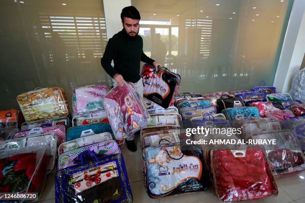 An Iraqi man arranges donation of blankets at the Turkmen Brotherhood Club headquarters in the capital Baghdad on February 8 to be sent to Turkey and...