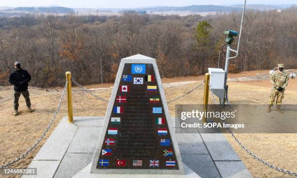 South Korean soldier and US soldier on guard next to a monument installed at a South Korean checkpoint during a media tour of the truce village of...