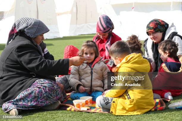 Turkish gendarmeries distribute hot meals to earthquake victims at tent city set up at a football field by the Disaster and Emergency Management...