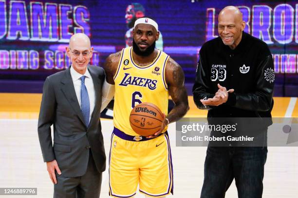 LeBron James, center, poses with Adam Silver, left and Kareem Abdul-Jabbar after becoming the all-time NBA scoring leader, passing Kareem...