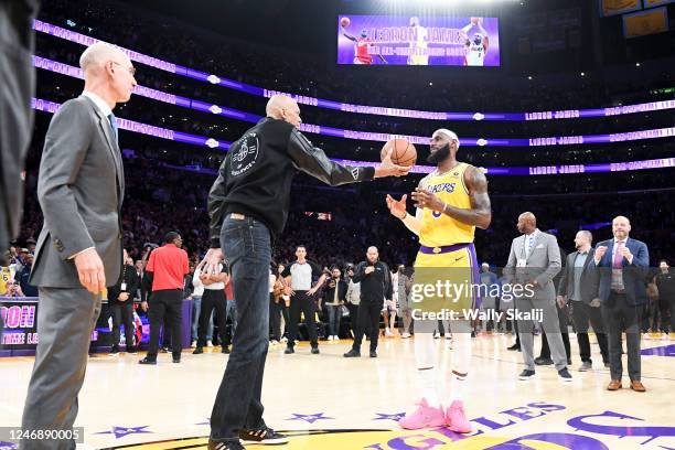 Kareem Abdul-Jabbar, left, hands a basketball to Los Angeles Lakers forward LeBron James after James passes him to become the all-time NBA scoring...