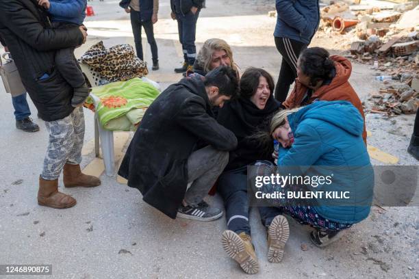People react in mourning next to the rubble of collapsed buildings in Hatay, southeastern Turkey, on February 8 two days after a strong earthquake...