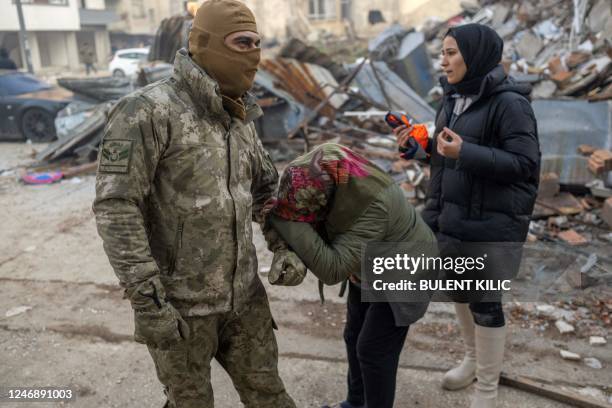 Woman pleads to a Turkish soldier to save her son, next to the rubble of a collapsed building in Hatay, southeastern Turkey, on February 8 two days...