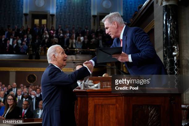 President Joe Biden shakes hands as he presents a copy of his speech to House Speaker Kevin McCarthy of Calif., before he delivers his State of the...