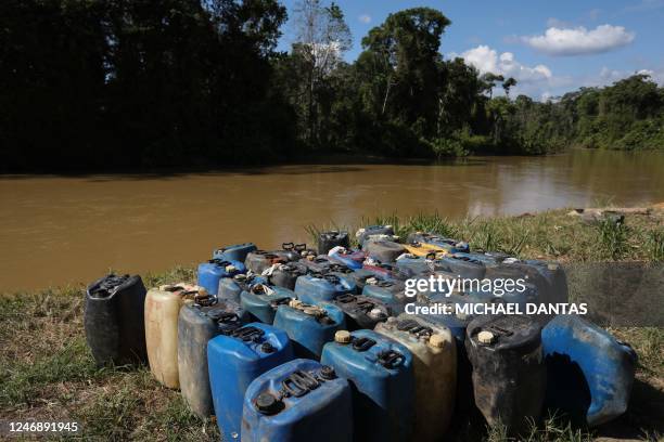 Containers used to transport fuel are seen at Porto do Arame, located on the banks of the Uraricoera river, the main access point for people trying...