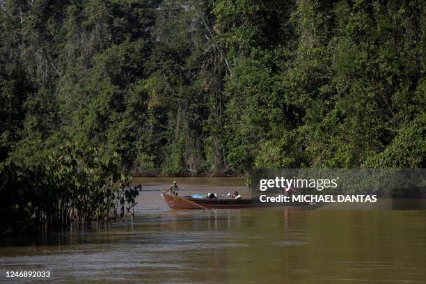 Alleged illegal miners leave an illegal mining area by boat as they pass through Porto do Arame, located on the banks of the Uraricoera river inside...