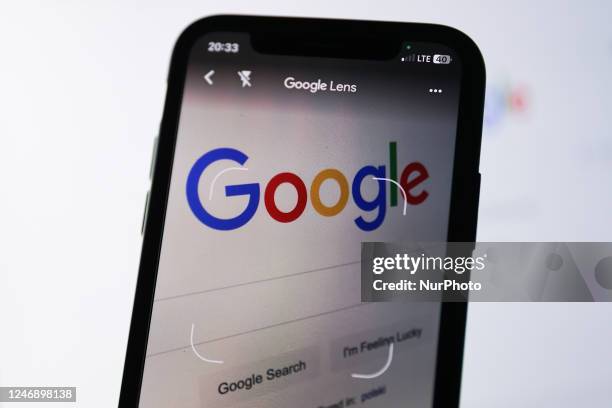 Google logo displayed on a laptop screen is seen on Google Lens app displayed on a phone screen in this illustration photo taken in Krakow, Poland on...