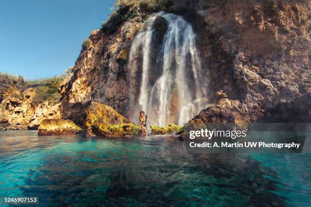 young woman wearing a bikini under a waterfall. - malaga fotografías e imágenes de stock