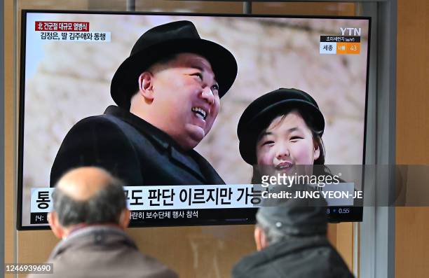 People watch a television screen showing a news broadcast with an image of North Korean leader Kim Jong Un and his daughter presumed to be named Ju...