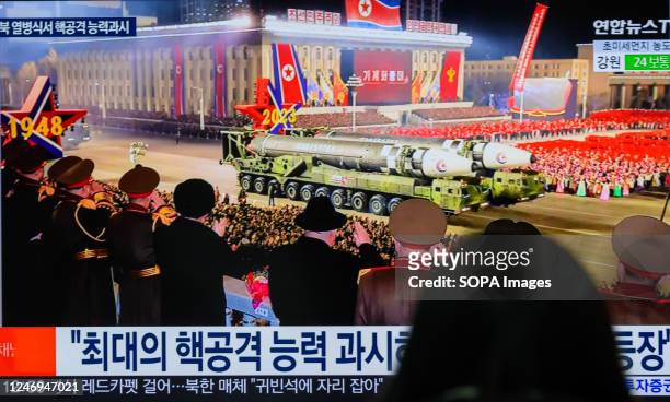 Person watches a television screen showing a news broadcast with an image of a North Korean military parade held in Pyongyang to mark the 75th...