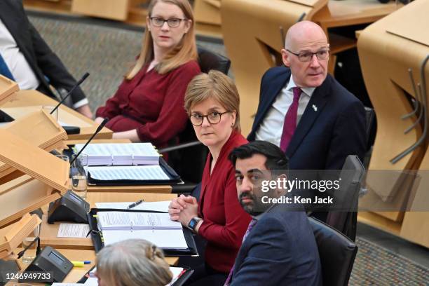 First Minister Nicola Sturgeon and her front bench team look round as protesters disrupt First Minister's Questions in the Scottish Parliament, on...