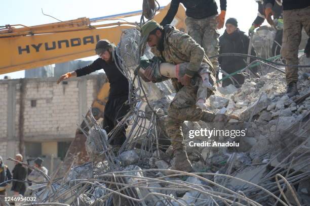 Member of the search and rescue team carries the dead body of a child who died under the rubble in the earthquake in Afrin district of Aleppo, Syria...