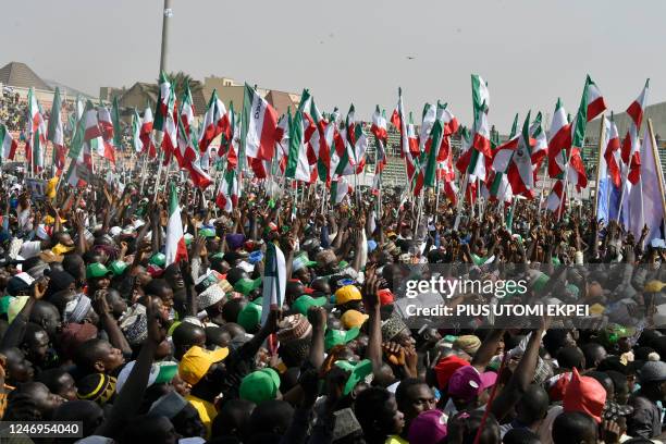 Supporters hold flags to support the candidate of the opposition Peoples Democratic Party Atiku Abubakar during a campaign rally in Kano, northwest...