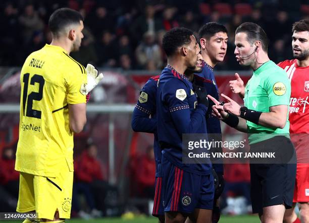 LtoR, Ajax goalkeeper Geronimo Rulli looks at Ajax' Dutch defender Jurrien Timber, Ajax' Mexican defender Edson Alvarez arguing with referee Danny...