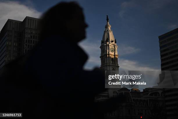 Woman crosses the street in front of an illuminated Philadelphia City Hall in advance of Sundays Super Bowl LVI on February 8, 2023 in Philadelphia,...