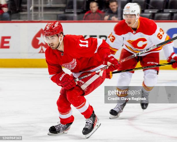 Filip Zadina of the Detroit Red Wings skates up ice in front of Adam Ruzicka of the Calgary Flames during the first period of an NHL game at Little...