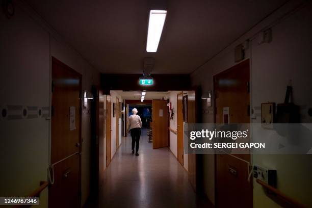 This photo taken on February 1, 2023 shows an elderly woman walking down the corridor at the retirement home in Broby, Southern Sweden. - For nearly...