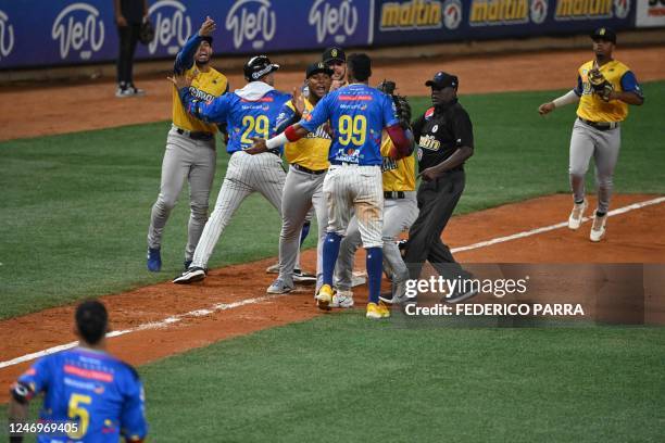 Venezuela's Leones del Caracas players argue with Colombia's Vaqueros de Monteria players during their Caribbean Series semi final baseball game, at...