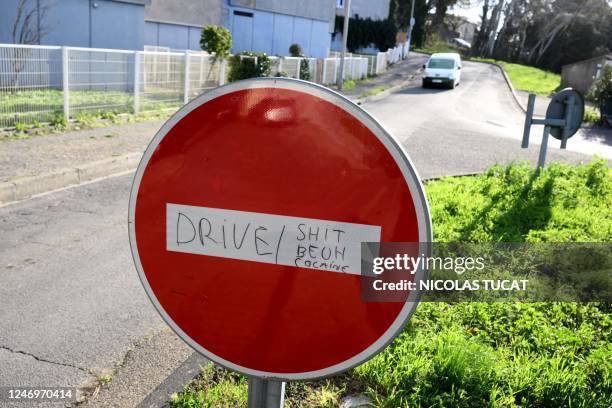 This picture taken on January 10, 2023 shows a stop sign with writing reading "Drive / hash, weed, cocaine" in the Bois de l'Ubac area of Carpentras,...