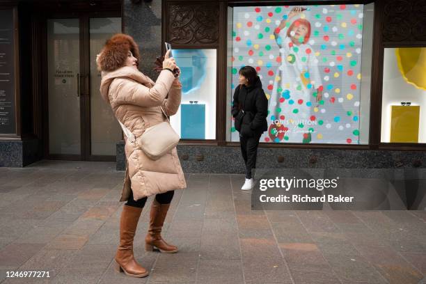 Members of the public interact with a screen featuring the artist Yayoi Kusama in a window of Harrods in Knightsbridge, on 9th February 2023, in...