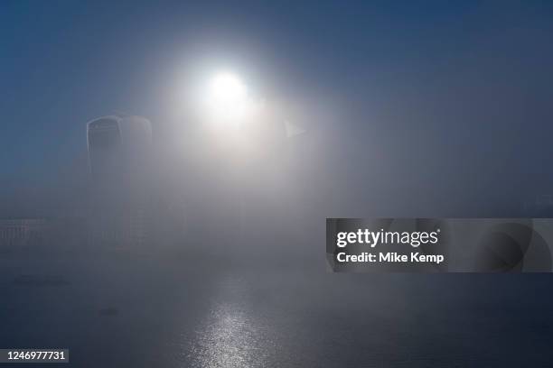 Thick fog overlooking the City of London skyline making a peaceful yet eerie atmosphere as structures appear and disappear over the River Thames and...