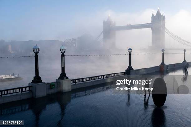 Thick fog starts to clear over the capital at Tower Bridge and the riverside walkway making a peaceful yet eerie atmosphere as structures appear and...