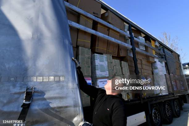 Driver closes the tarpaulin of a truck, containing humanitarian aid collected by Croatian government, Caritas and the Croatian Red Cross and...