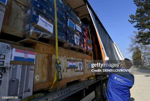 Driver closes the tarpaulin of a truck, containing humanitarian aid collected by Croatian government, Caritas and the Croatian Red Cross and...