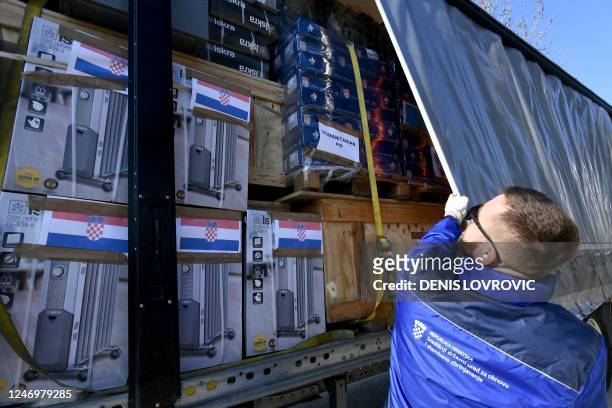 Driver closes the tarpaulin of a truck, containing humanitarian aid collected by Croatian government, Caritas and the Croatian Red Cross and...