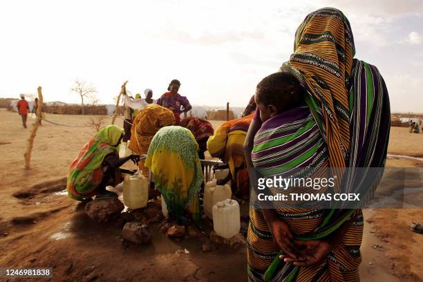 Sudanese refugees collect water 26 June 2004 in Chad at the Iridimi refugee camp harbouring 15,000 refugees who fled the Darfur region where rebels...