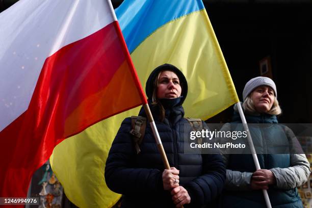 Women hold Ukrainian and Polish flags during a demonstration of solidarity with Ukraine on day 352nd of Russian invasion on Ukraine. Krakow, Poland...