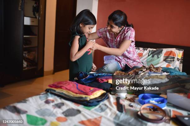 mother looking at neckless her daughter is wearing while arranging the wardrobe - clean closet stock pictures, royalty-free photos & images