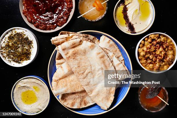 Pita with spreads baba ganoush, labneh, muhammara, a Sour cocktail, hummus, balila, and a Neat cocktail at Yasmine located inside Union Market...