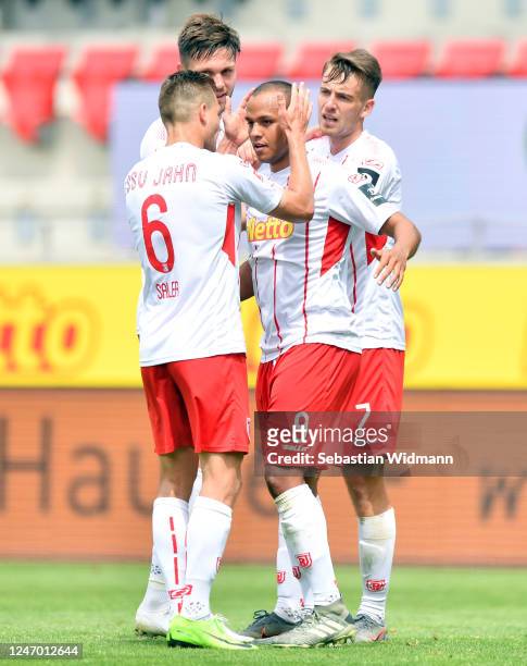 Jann George of Regensburg celebrates his team's second goal with teammates Benedikt Saller and Max Besuschkow during the Second Bundesliga match...