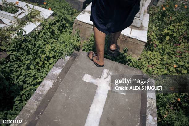 Woman walks on graves during a gathering of sapeurs in Kinshasa, capital of the Democratic Republic of Congo, on February 10, 2023. - Flamboyant...