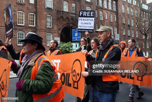 Activists from the Just Stop Oil climate change campaign group hold up placards as they march from Pentonville Prison in north London on February 11...