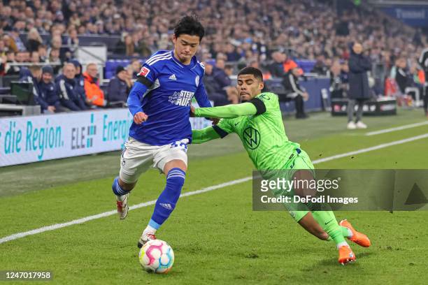 Soichiro Kozuki of FC Schalke 04 and Paulo Otavio of VfL Wolfsburg battle for the ball during the Bundesliga match between FC Schalke 04 and VfL...