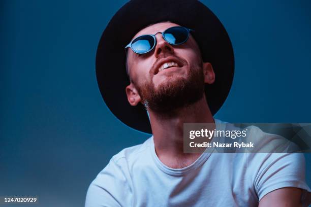 portrait of young handsome man in eyeglasses and hat - teal portrait stock pictures, royalty-free photos & images