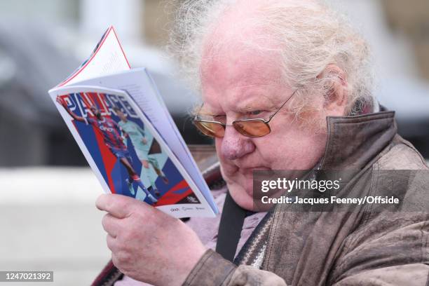 Fan reads the match programme during the Premier League match between Crystal Palace and Brighton & Hove Albion at Selhurst Park on February 11, 2023...