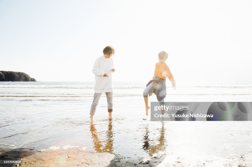 A boy and a girl playing on the water's edge