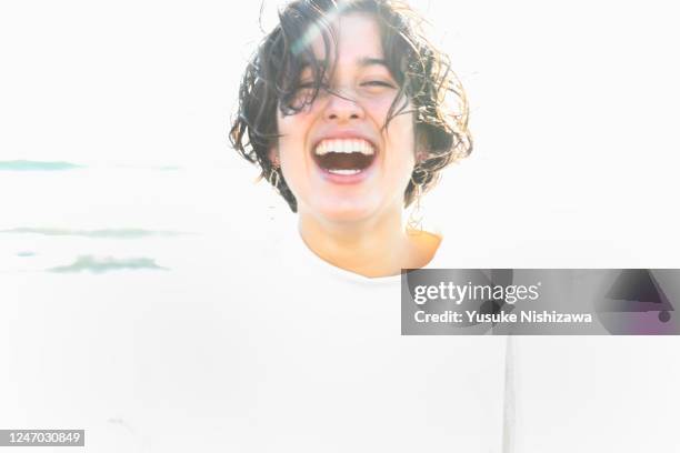 a teenage girl smiling at the sea - smiling controluce foto e immagini stock