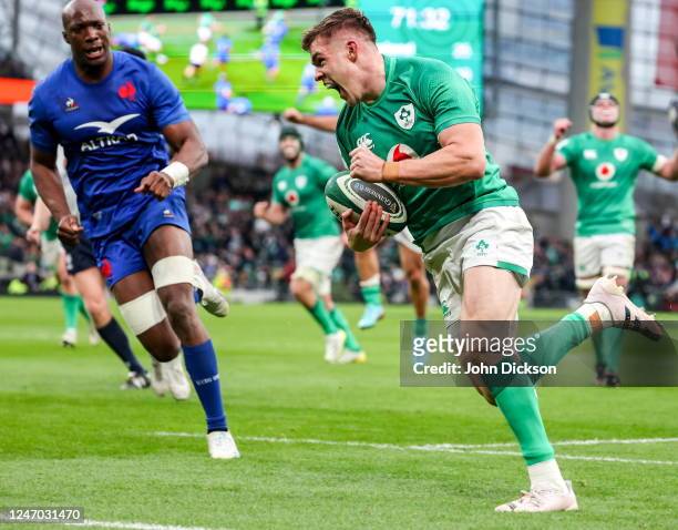 Dublin , Ireland - 11 February 2023; Garry Ringrose of Ireland on his way to scoring his side's fourth try, in the 72nd minute, despite the tackle of...