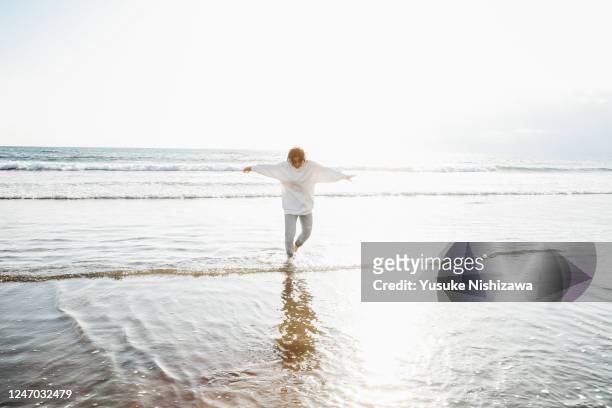 a teenage girl playing on the water's edge - soft focus stock pictures, royalty-free photos & images
