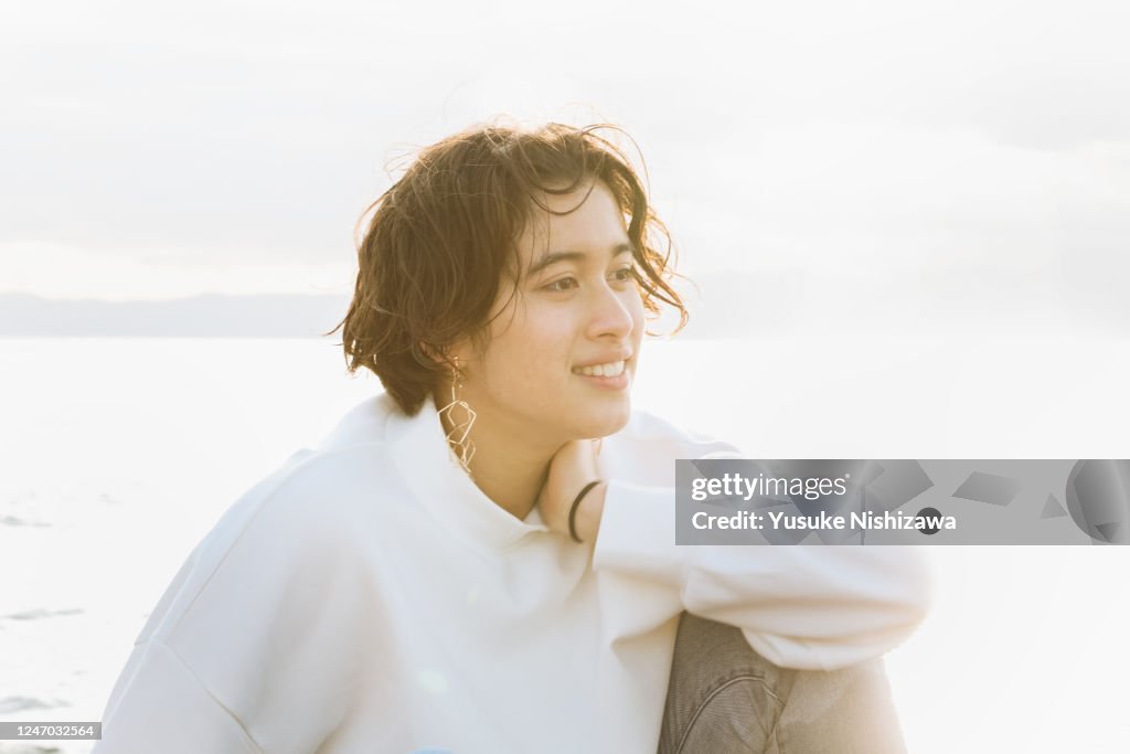 A teenage girl staring into the distance and smiling