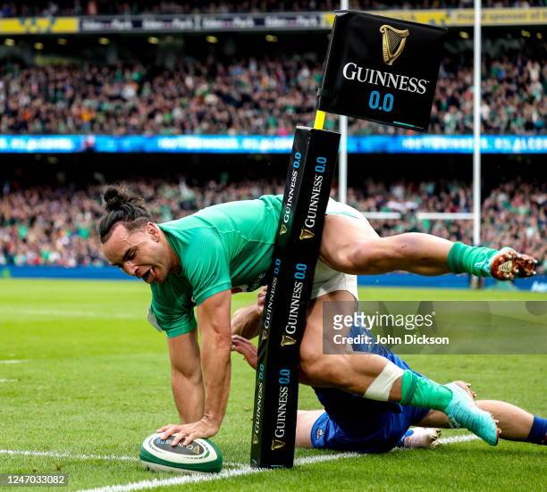 Dublin , Ireland - 11 February 2023; James Lowe of Ireland scores his side's second try in the 21st minute despite the tackle of Damian Penaud of...