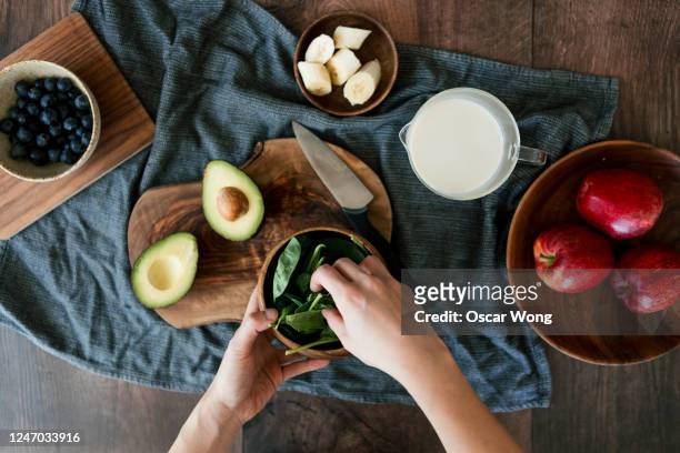 preparing vegan food on a wooden worktop - avocado smoothie stock-fotos und bilder