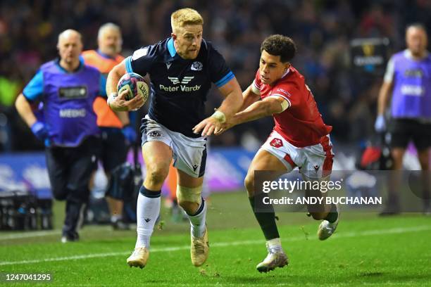 Scotland's wing Kyle Steyn runs away from Wales' wing Rio Dyer during the Six Nations international rugby union match between Scotland and Wales at...